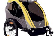 Dětský přívěsný vozík Burley je vybaven ochranou před deštěm i madlem a třetím kolečkem, které umožňují jet s vozíkem jako s kočárkem
