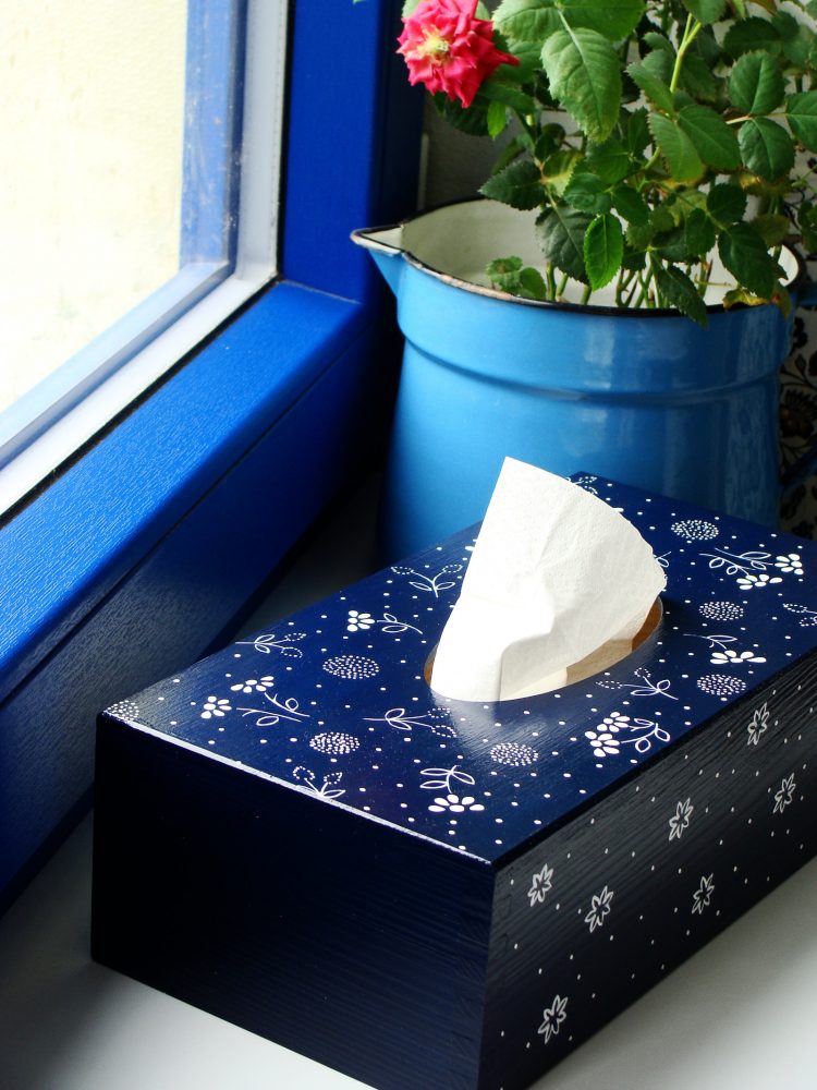 dřevěná krabice s vysouvacím dnem malovaná tmavou modří a dekorovaná bílou barvou ve stylu modrotisku je určena na papírové kapesníky. 550 Kč (Fler, rolinda)