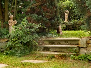 Krásné staré schody, s nimiž kontrastují zídky z hrubě opracovaných kamenů, lákají do tajuplných zákoutí zahrady. Romantickou atmosféru ještě podtrhují keramické plastiky. Foto: Zdeněk Roller