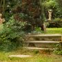 Krásné staré schody, s nimiž kontrastují zídky z hrubě opracovaných kamenů, lákají do tajuplných zákoutí zahrady. Romantickou atmosféru ještě podtrhují keramické plastiky. Foto: Zdeněk Roller