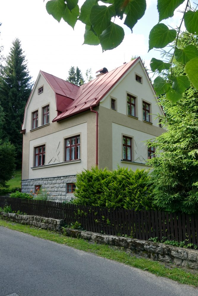 Podél hlavních cest se můžeme setkat s poměrně velkými zděnými domy. Většinou se jedná o dvoukřídlé symetrické stavby s vchodem a schodištěm uprostřed, ale někdy je stavba poloviční jako na tomto obrázku