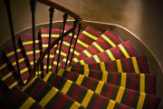 Tmavé schodiště rozsvítil pestrý koberec s výrazným dekorem pruhů. Foto: Shutterstock