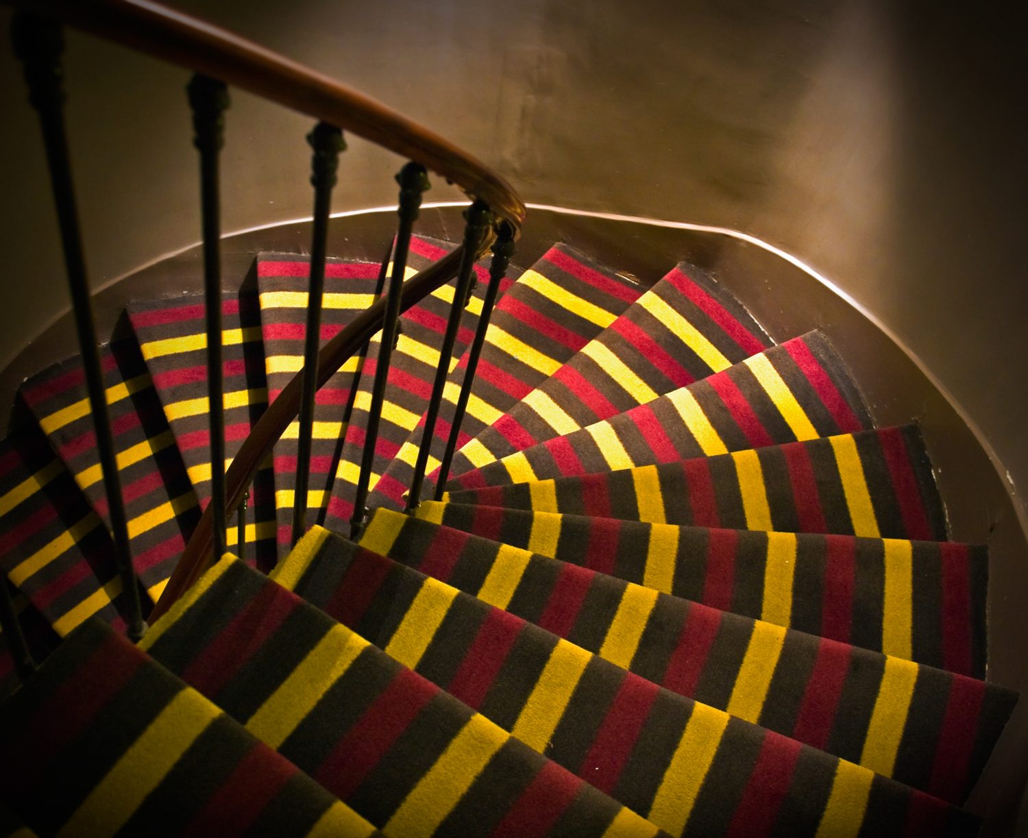 Tmavé schodiště rozsvítil pestrý koberec s výrazným dekorem pruhů. Foto: Shutterstock