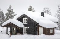 Starý srub pod závějemi sněhu