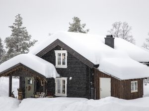 Starý srub pod závějemi sněhu