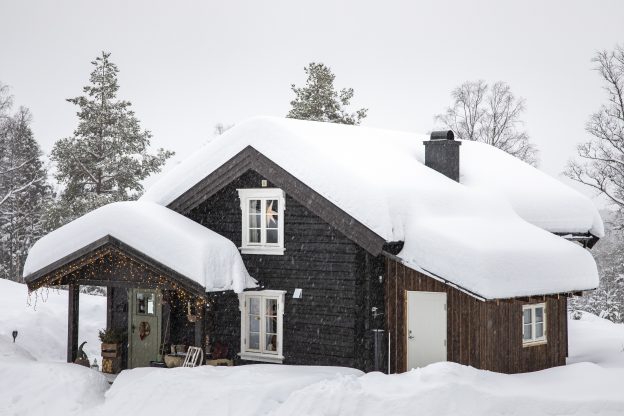 Starý srub pod závějemi sněhu
